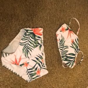 A bathing suit with pink flowers and green leaves